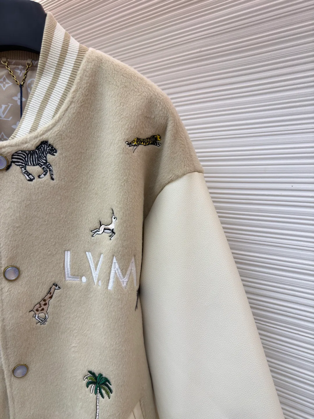 LOUIS VUITTON animal embroidered baseball uniform ●Original version: 48000 purchased and developed ●Item number: 1682284-B90 ●Fabric: cotton fabric ●Technology: embroidery production ●Color: apricot ●Version: fitted version ●Weight: about 1070 grams ●Size: 46-48-50-52 ●Description: The main body of this Louis Vuitton embroidered baseball jacket is made of high-quality wool blended fabric, which is crisp and soft. The sleeves are made of eco-friendly artificial leather with a matte texture, which contrasts with the body in terms of material and touch. The animal, palm tree and other patterns on the body of the clothing are all completed by hand-stitched embroidery technology, using multi-color embroidery threads to embroider in layers. The patterns are three-dimensional and vivid, and the stitching in the details is fine and even. The letter logo uses flat embroidery technology, and the font outline is clear and regular. The ribbed collar, cuffs and hem of the jacket are made of high-elastic knitted fabric, which will not loosen easily after being worn for a long time. The metal snaps on the placket are custom-made hardware with a thick texture and anti-oxidation. The overall tailoring is a loose oversize version, and the splicing uses hemming stitching technology, and the lines are smooth and smooth. Every craft detail is in line with the brand's luxury product production standards, creating a ready-to-wear garment that has both a sense of design and practical wearability. The overall wiring is straight and delicate, the fabric is comfortable and soft, and the color is consistent without color difference. It can be matched with the same style to create a fashionable look and control various occasions. Customized accessories, complete with three standards, same style for men and women!